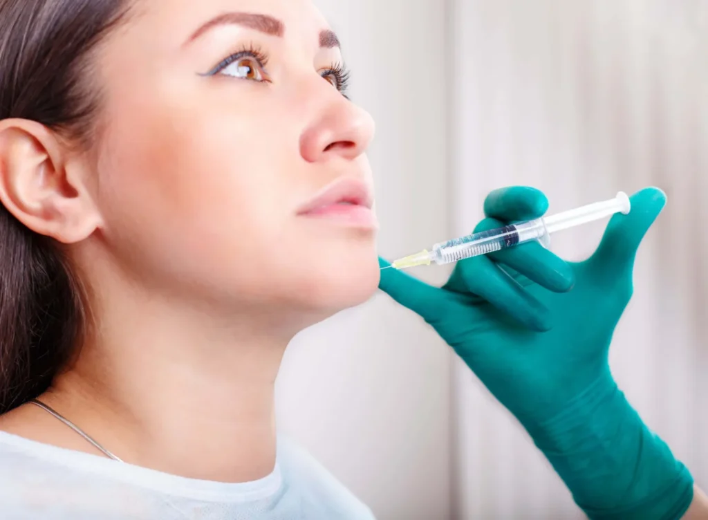 Profile shot of woman receiving precise Exosome therapy on the chin/jawline area for structural and cellular skin rejuvenation.