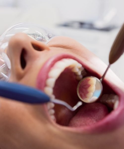 dentist-examining-female-patient-with-tools_107420-65513